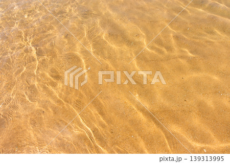 Ripples of water waves reflecting texture on a sandy beach bottom Ripples of water waves reflecting texture on a sandy beach bottom 139313995