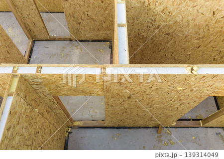 Construction of new and modern modular house. Walls made from composite wooden sip panels with styrofoam insulation inside. Building new frame of energy efficient home concept. Construction of new and modern modular house. Walls made from composite wooden sip panels with styrofoam insulation inside. Building new frame of energy efficient home concept. 139314049