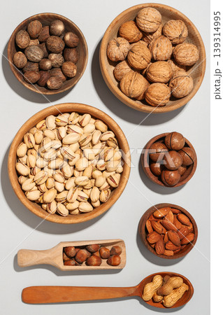 Nuts in wooden bowls on a gray background Nuts in wooden bowls on a gray background 139314995