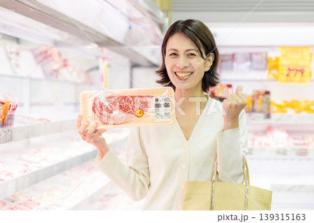 スーパーでお肉を買う女性買い物客 スーパーでお肉を買う女性買い物客 139315163