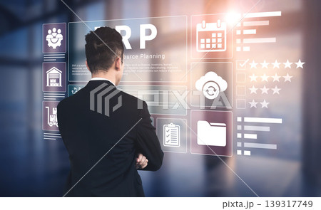 Businessman Interacting with Digital ERP Dashboard Displaying Various Business Tools and Resources in a Modern Office Environment Ledger 139317749