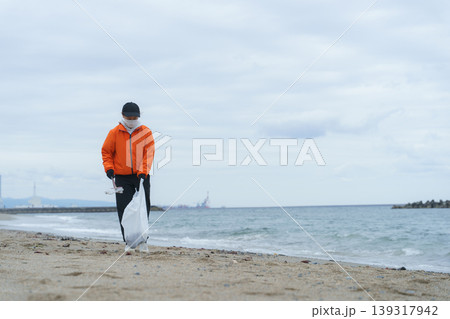 砂浜でゴミ拾いをする人 砂浜でゴミ拾いをする人 139317942