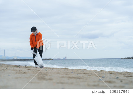 砂浜でゴミ拾いをする人 砂浜でゴミ拾いをする人 139317943