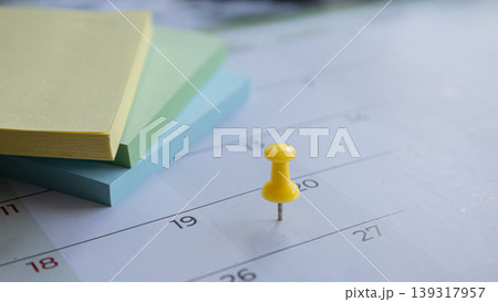 Yellow pushpin marking date on calendar 139317957