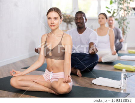 Meditation of group of sports people of different nationalities in yoga class Meditation of group of sports people of different nationalities in yoga class 139318853