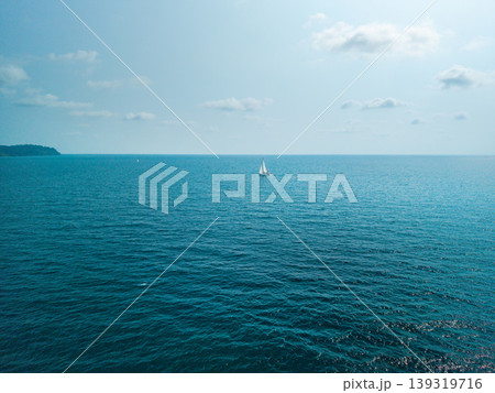 Minimalist seascape with a white sailboat in the middle of the deep blue ocean, Thailand Minimalist seascape with a white sailboat in the middle of the deep blue ocean, Thailand 139319716