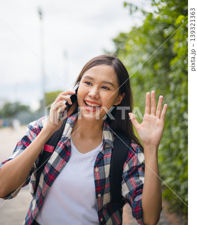 Young woman smiles warmly while talking on phone Young woman smiles warmly while talking on phone 139321363