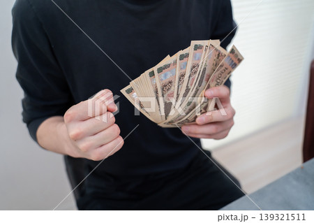 お金を持ってガッツポーズする男性 お金を持ってガッツポーズする男性 139321511