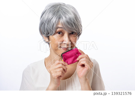 ピンク色のがま口を両手で持ち嬉しそうなシニア女性 ピンク色のがま口を両手で持ち嬉しそうなシニア女性 139321576