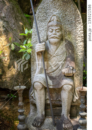 Ancient stone statue with staff on Miyajima Island, Japan 139321586