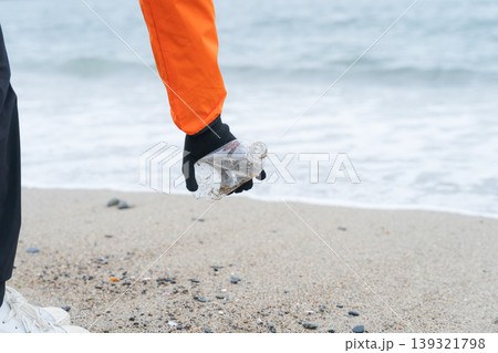 砂浜でゴミ拾いをする人 139321798
