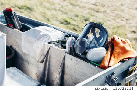 protective equipment stored in wooden box outdoors, safety goggles respirator and orange work gloves arranged, field work in natural environment, construction, industry, safety protective equipment stored in wooden box outdoors, safety goggles respirator and orange work gloves arranged, field work in natural environment, construction, industry, safety 139322211