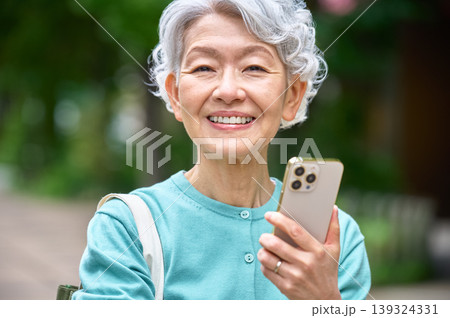 スマートフォンを持って満面の笑みのシニア女性 139324331