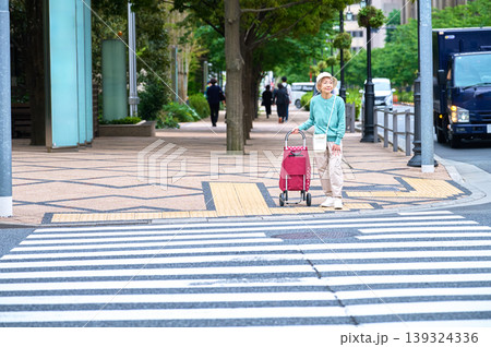 街の交差点でショッピングカートを引くシニア女性 街の交差点でショッピングカートを引くシニア女性 139324336