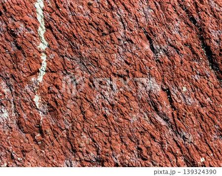 Close-up texture of natural red stone with white mineral veins. Close-up texture of natural red stone with white mineral veins. 139324390