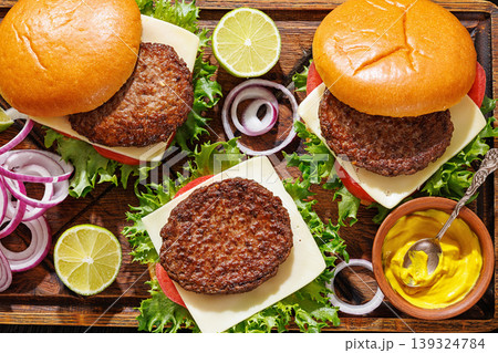 beef cheeseburgers with brioche buns on a tray beef cheeseburgers with brioche buns on a tray 139324784