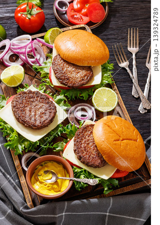 beef cheeseburgers with brioche buns on a tray beef cheeseburgers with brioche buns on a tray 139324789