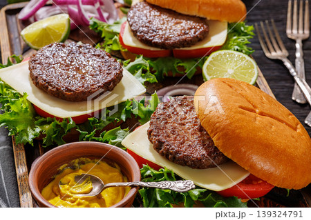 beef cheeseburgers with brioche buns on a tray beef cheeseburgers with brioche buns on a tray 139324791