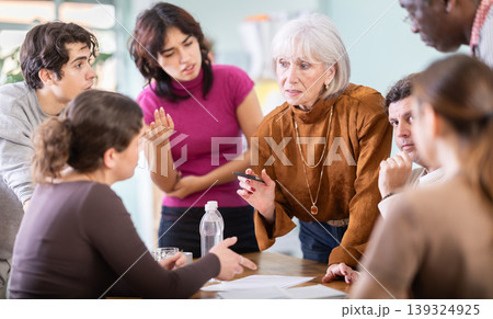 group of people look at documents and discuss questions 139324925