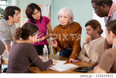 Men and women of different ages actively communicating at table Men and women of different ages actively communicating at table 139324931