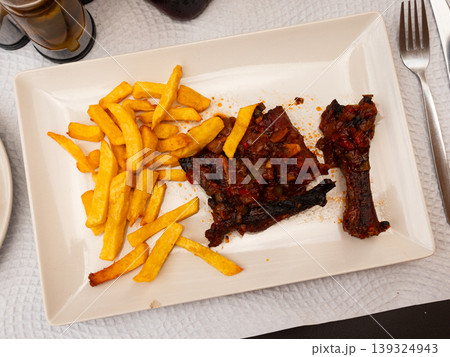 Fried pork ribs served with potatoes on plate 139324943