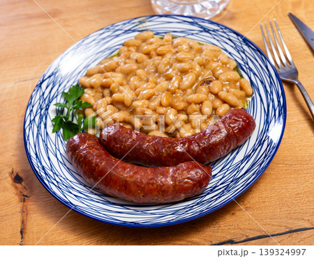 Hot delicious sausages with beans and parsley on plate Hot delicious sausages with beans and parsley on plate 139324997