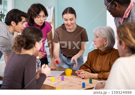 Group of focused people playing board game around a table Group of focused people playing board game around a table 139324999
