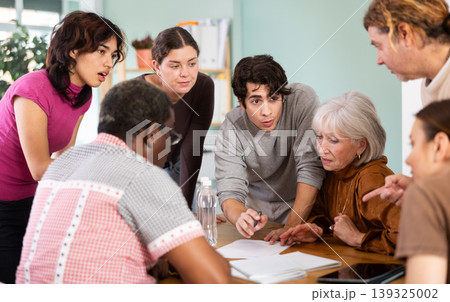 group of people look at documents and discuss questions 139325002