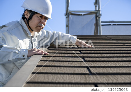 戸建て住宅の屋根材を確認する男性作業員 戸建て住宅の屋根材を確認する男性作業員 139325068