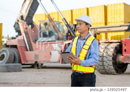 Asian Logistics Supervisor Standing with Tablet by Reach Stacker in Thailand Port Site Asian Logistics Supervisor Standing with Tablet by Reach Stacker in Thailand Port Site 139325497