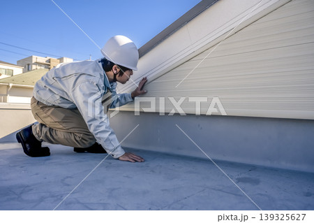 戸建て住宅の外壁確認をする男性　リフォーム前 139325627