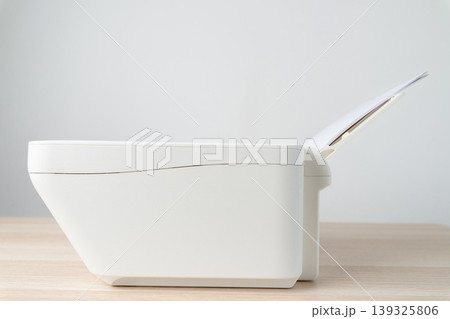 White office printer with a stack of blank A4 paper loaded in the feeder tray, shown in a clean minimalist workspace. Conceptual image for printing, office equipment, productivity and documentation. White office printer with a stack of blank A4 paper loaded in the feeder tray, shown in a clean minimalist workspace. Conceptual image for printing, office equipment, productivity and documentation. 139325806