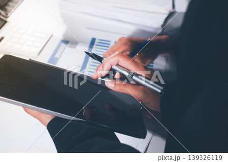 Professional photo of a person's hands reviewing a contract or legal document on a desk, for concepts of business, finance, and legal affairs Professional photo of a person's hands reviewing a contract or legal document on a desk, for concepts of business, finance, and legal affairs 139326119