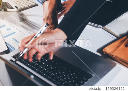 Professional photo of a person's hands reviewing a contract or legal document on a desk, for concepts of business, finance, and legal affairs 139326122