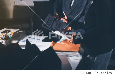 Professional photo of a person's hands reviewing a contract or legal document on a desk, for concepts of business, finance, and legal affairs 139326129