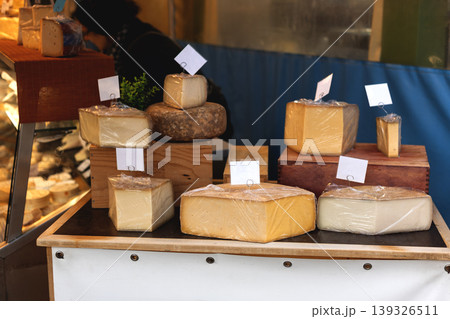 Artisan Cheese Display at Market Stall with Various Cheese Wheels Artisan Cheese Display at Market Stall with Various Cheese Wheels 139326511