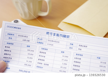 給料日に給与明細を確認する男性の手元 給料日に給与明細を確認する男性の手元 139326530