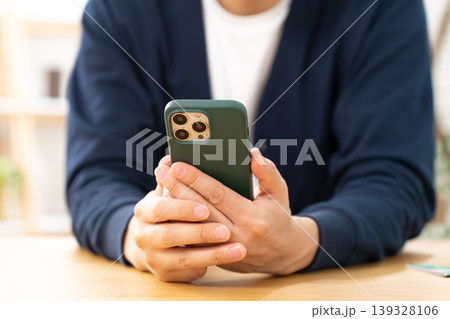 スマホを見て悩む男性 手元 スマホを見て悩む男性 手元 139328106