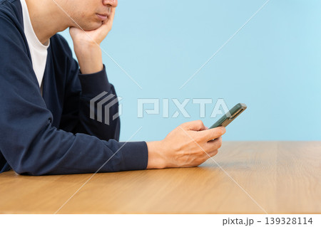 スマホを見て悩む男性 手元 横向き スマホを見て悩む男性 手元 横向き 139328114