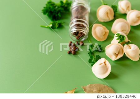 Uncooked ravioli with herbs and pepper on clean surface 139329446