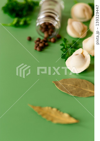 Cooking ingredients with tortellini and spices on green background Cooking ingredients with tortellini and spices on green background 139329447