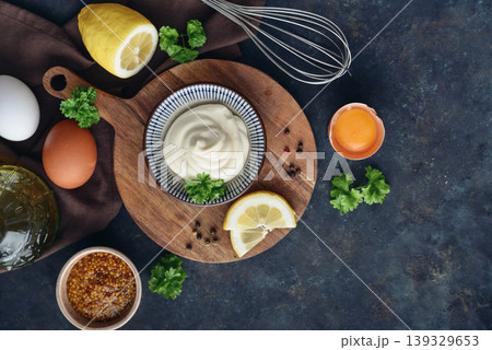 Top view of homemade mayonnaise in a bowl on a wooden board with fresh ingredients Top view of homemade mayonnaise in a bowl on a wooden board with fresh ingredients 139329653