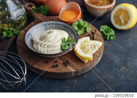 Homemade mayonnaise in a bowl on a wooden board with fresh ingredients Homemade mayonnaise in a bowl on a wooden board with fresh ingredients 139329658