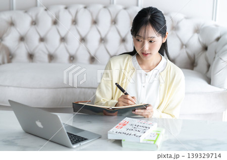 オンラインレッスンでメモを取る若い女性 オンラインレッスンでメモを取る若い女性 139329714