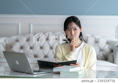 自宅のリビングで手帳に予定を書き込む笑顔の女性 ライフスタイル キャリア 勉強 自己啓発 自宅のリビングで手帳に予定を書き込む笑顔の女性 ライフスタイル キャリア 勉強 自己啓発 139329716
