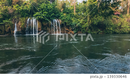 Sai Yok Yai waterfall in Thailand flowing into river surrounded by lush tropical jungle in national park, Wide scenic cascade with rich textures and natural beauty, travel and tranquility Sai Yok Yai waterfall in Thailand flowing into river surrounded by lush tropical jungle in national park, Wide scenic cascade with rich textures and natural beauty, travel and tranquility 139330646
