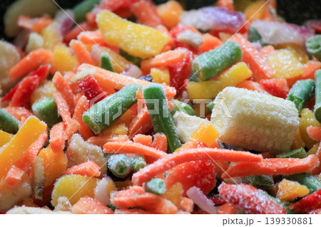 Assorted sliced frozen vegetables with ice crystals including colorful peppers carrots and baby corn Assorted sliced frozen vegetables with ice crystals including colorful peppers carrots and baby corn 139330881