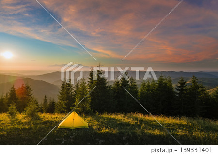 Camping tent on trekking trail for hikers shelter. Mountain campsite at bright sunset. Active tourism and hiking concept Camping tent on trekking trail for hikers shelter. Mountain campsite at bright sunset. Active tourism and hiking concept 139331401
