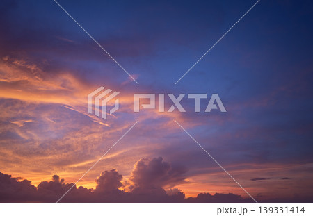 Bright sunset with setting sun behind vivid orange and yellow clouds 139331414