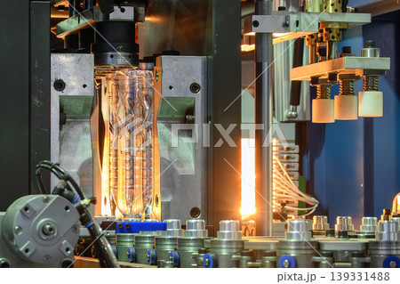 Mass production of PET bottles placed upside down from a blow molding machine on an automated line. Mass production of PET bottles placed upside down from a blow molding machine on an automated line. 139331488